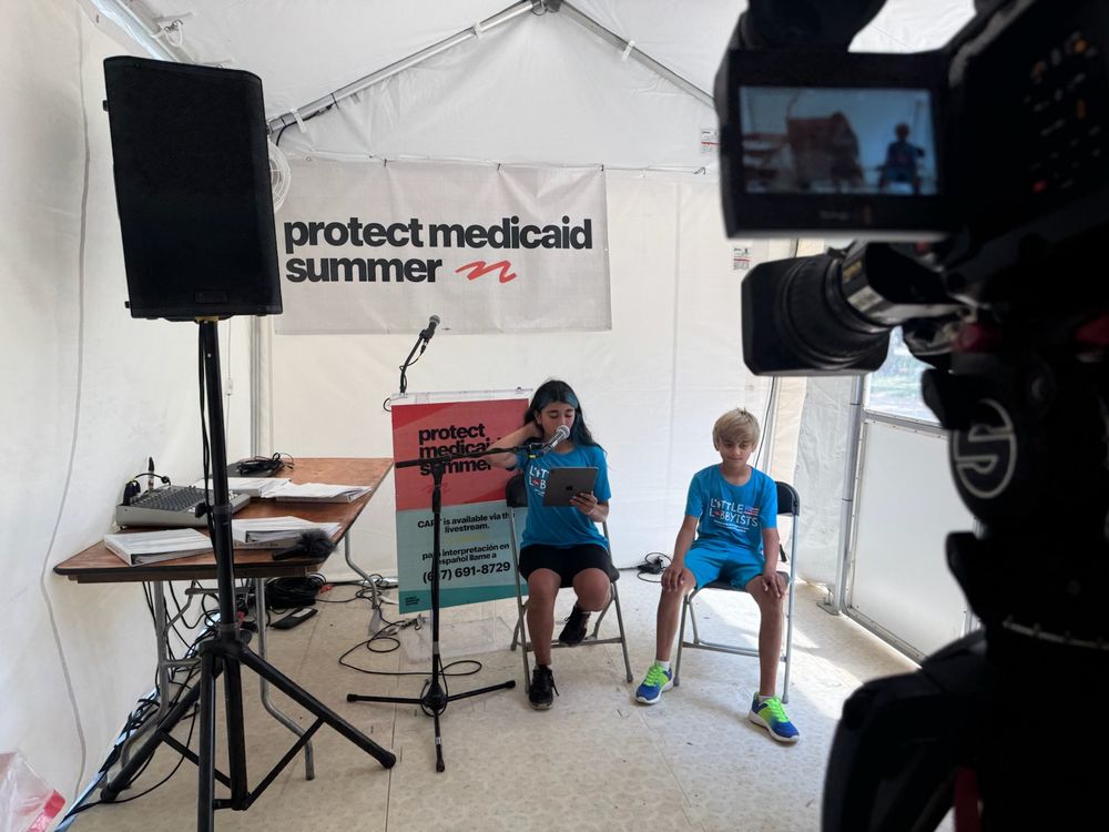 Little Lobbyists families sit in front of a livestream camera feed to read their Medicaid stories