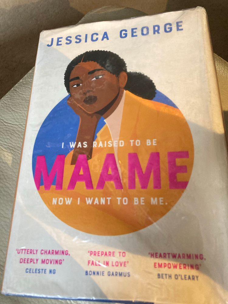 Book cover of Maame by Jessica George depicting a Black woman in an orange dress.