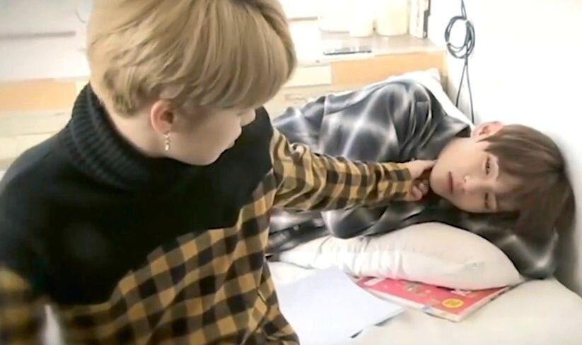 2016-ish vmin with tae lying in bed and jimin sitting on the bed, reaching out to gently touch his chin