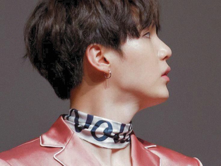 profile shot of yoongi in pink satiny pajamas with a silk/satin(?) scarf around his neck