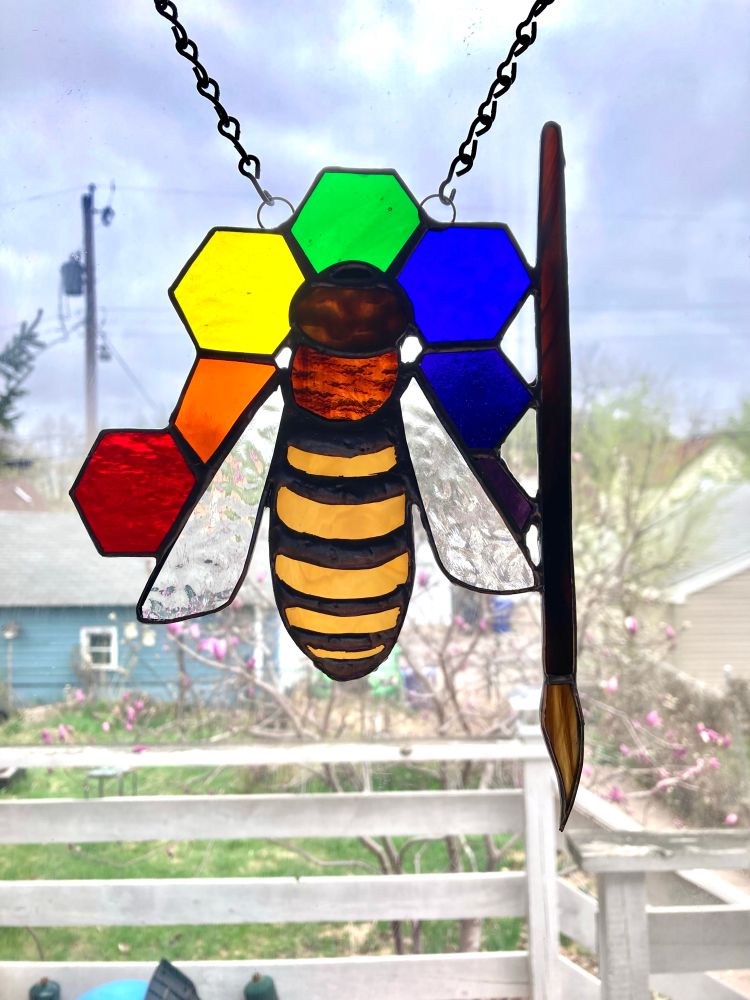 Honeybee with painters brush and the honey comb is colored like a painters pallet.
