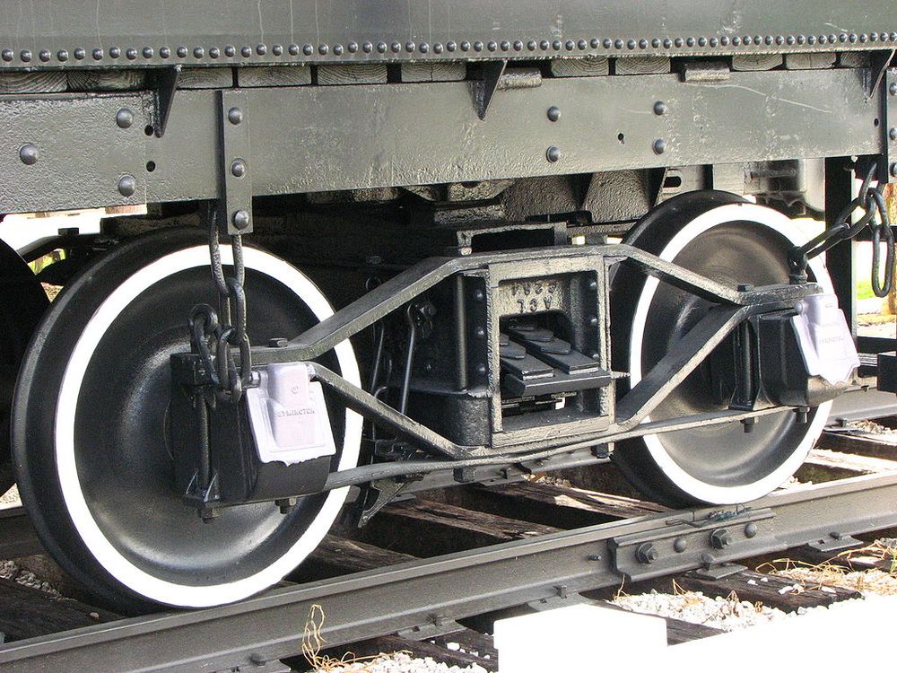 A closeup of arch bar style trucks. The sideframe is not a single cast piece, instead being constructed out of metal bars bent to shape.