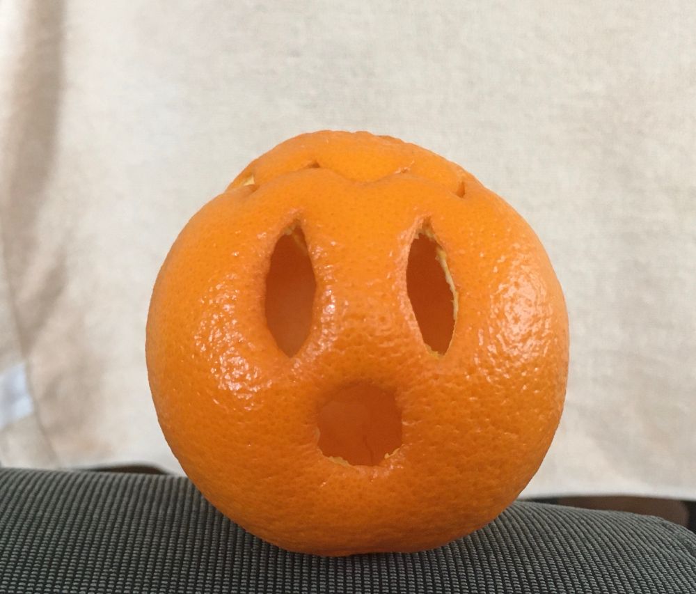 Tangerine carved into a jack-o-lantern.