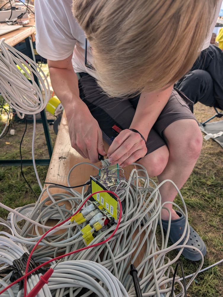 Steph leaning over a bundle of Cat5e and a mess of protoboard 