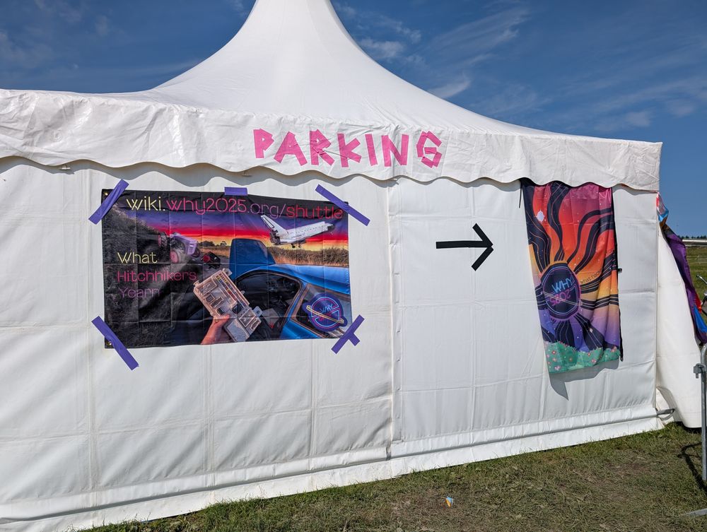 A white tent with "parking" made out of tape. 

The shuttle flag is taped on, next to the WHY flag 