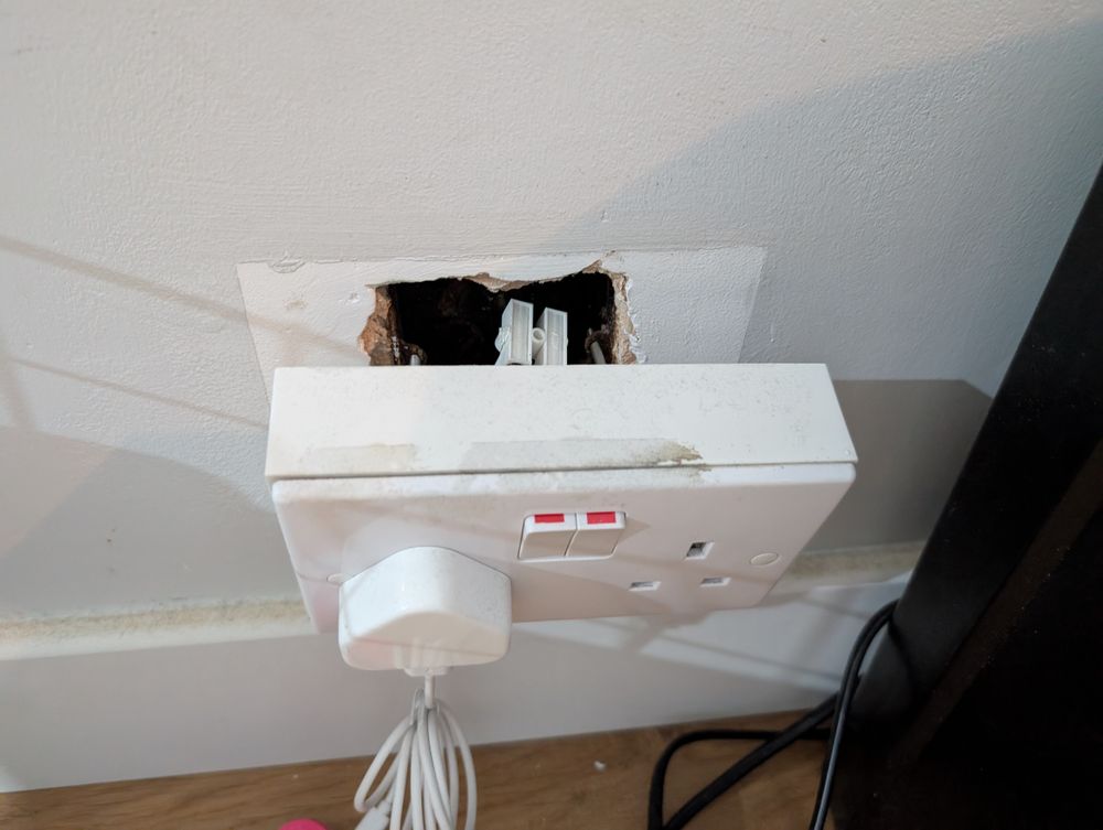 A box and UK switch facia plate, hanging off the wall 