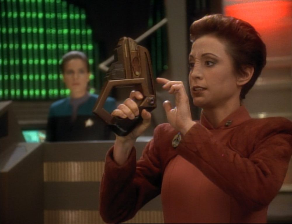 A screenshot from Star Trek: DS9. Kira Nerys in the foreground holds a phaser at the ready while Jadzia Dax in the background looks on