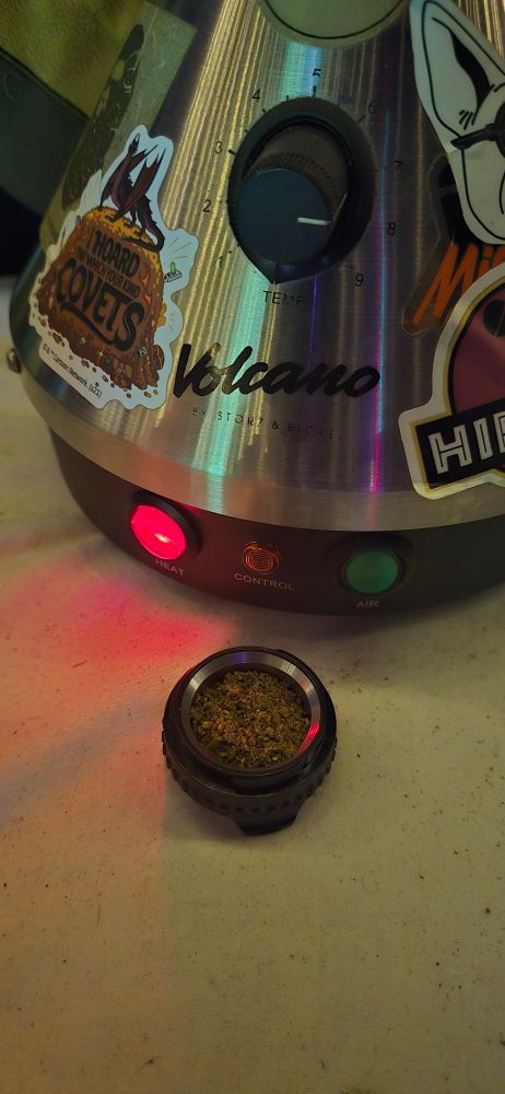 A picture of a loaded up chamber of weed next to a volcano vaporizer 