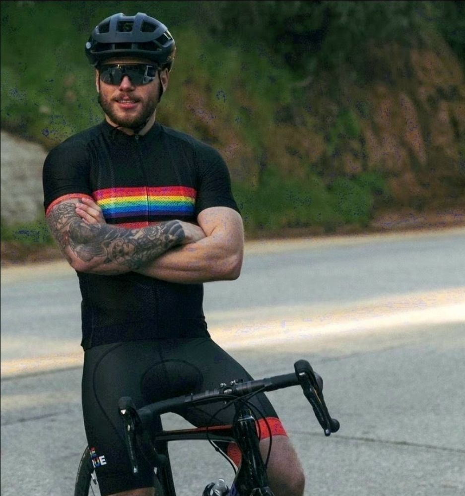 Gus Kenworthy suited up in a cycling kit, sitting on his bike. (Lucky bike).
