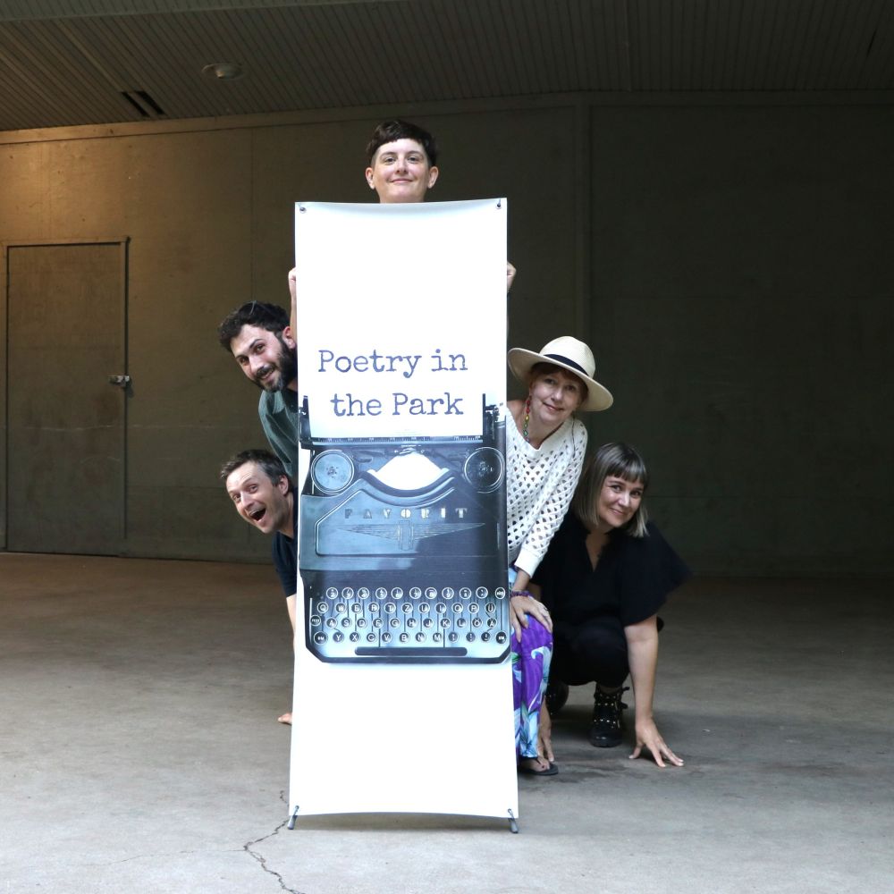 Poets hiding behind tall, vertical Poetry in the Park banner. From left to right: Rob Taylor, Dominique Bernier-Cormier, andrea bennett, Janey Kvammen, Jessica Lee McMillan. 