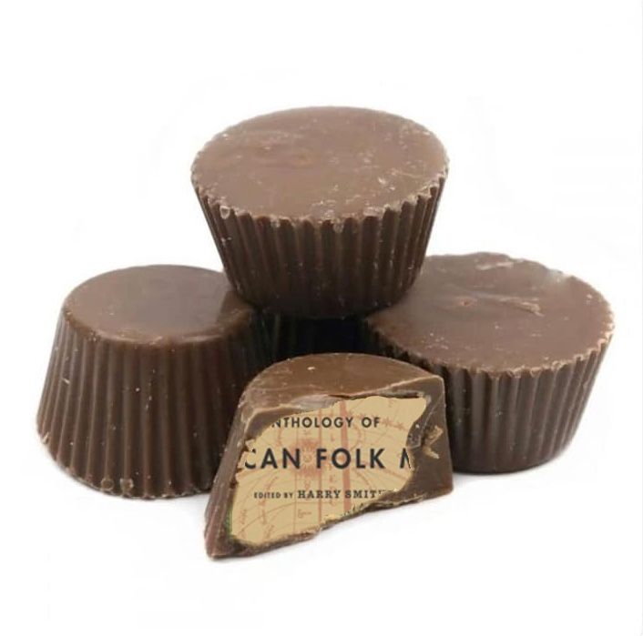 A stack of Reese's Peanut Butter Cups. One has a bite taken out of it, revealing the partial label of Harry Smith's Anthology of American Folk Music.