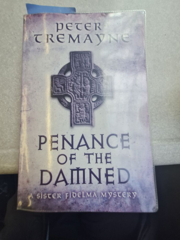 Purple book cover showing a medieval stone cross in the centre and the title "Penance of the Damned: A sister Fidelma mystery" by Peter Tremayne 