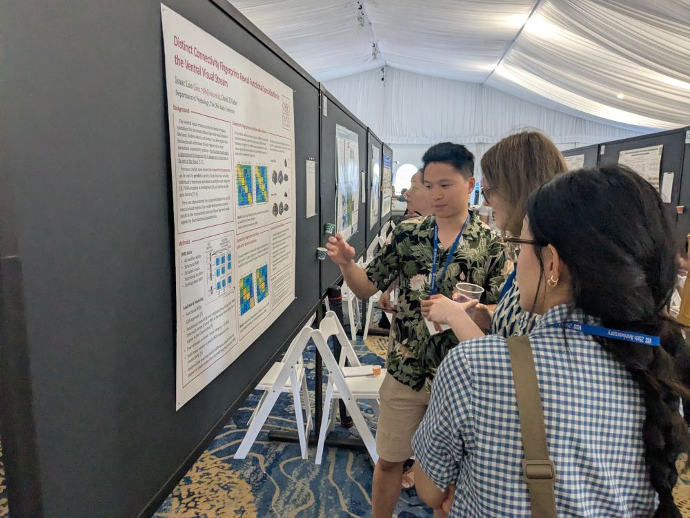 Isaac discusses his poster, entitled "Distinct connectivity fingerprints reveal functional specialization in the ventral visual stream", with viewers at VSS 2025.