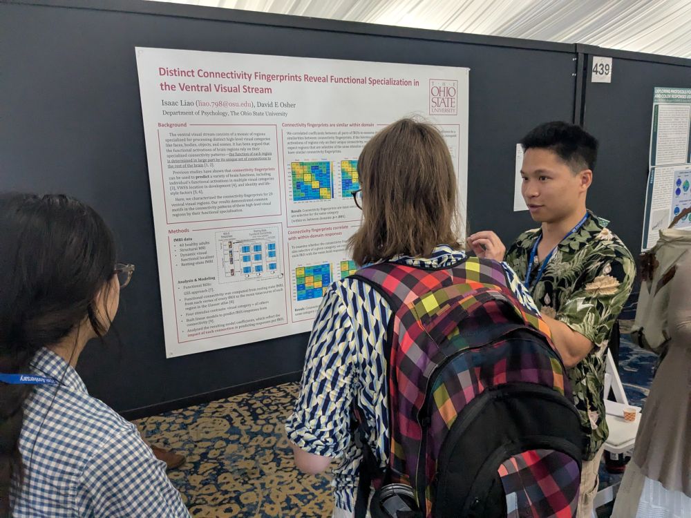 Isaac discusses his poster, entitled "Distinct connectivity fingerprints reveal functional specialization in the ventral visual stream", with viewers at VSS 2025.