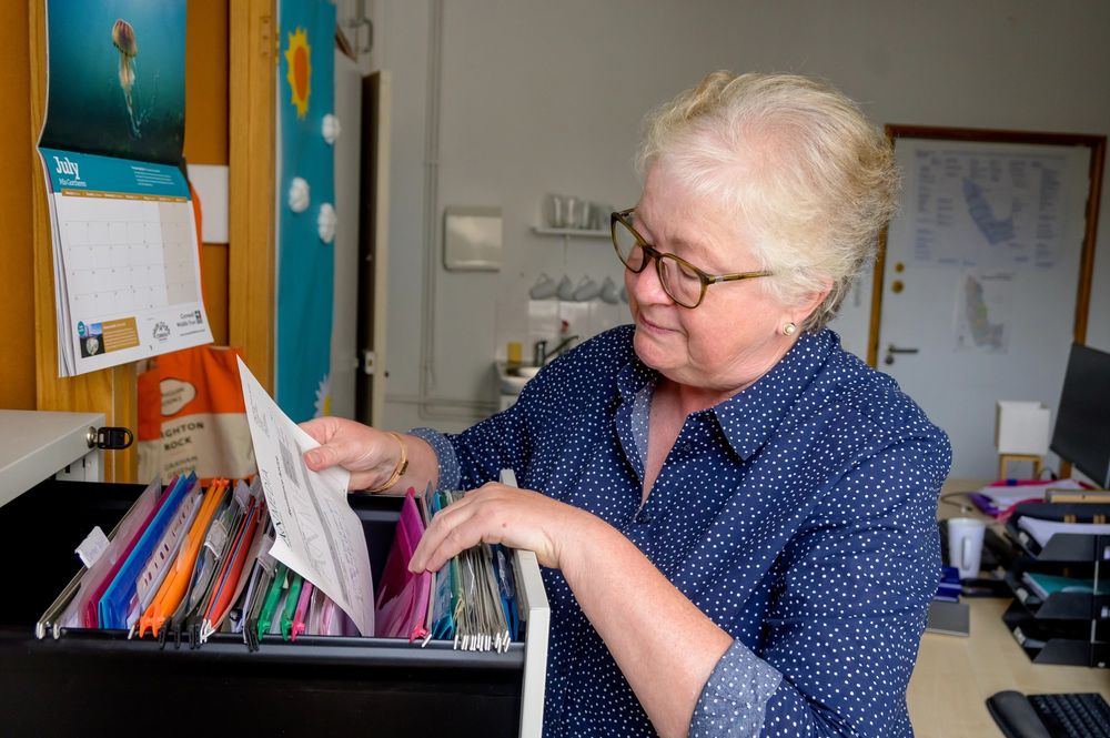 Woman looks through files in a cabinet. Image credit: Age Without Limits.