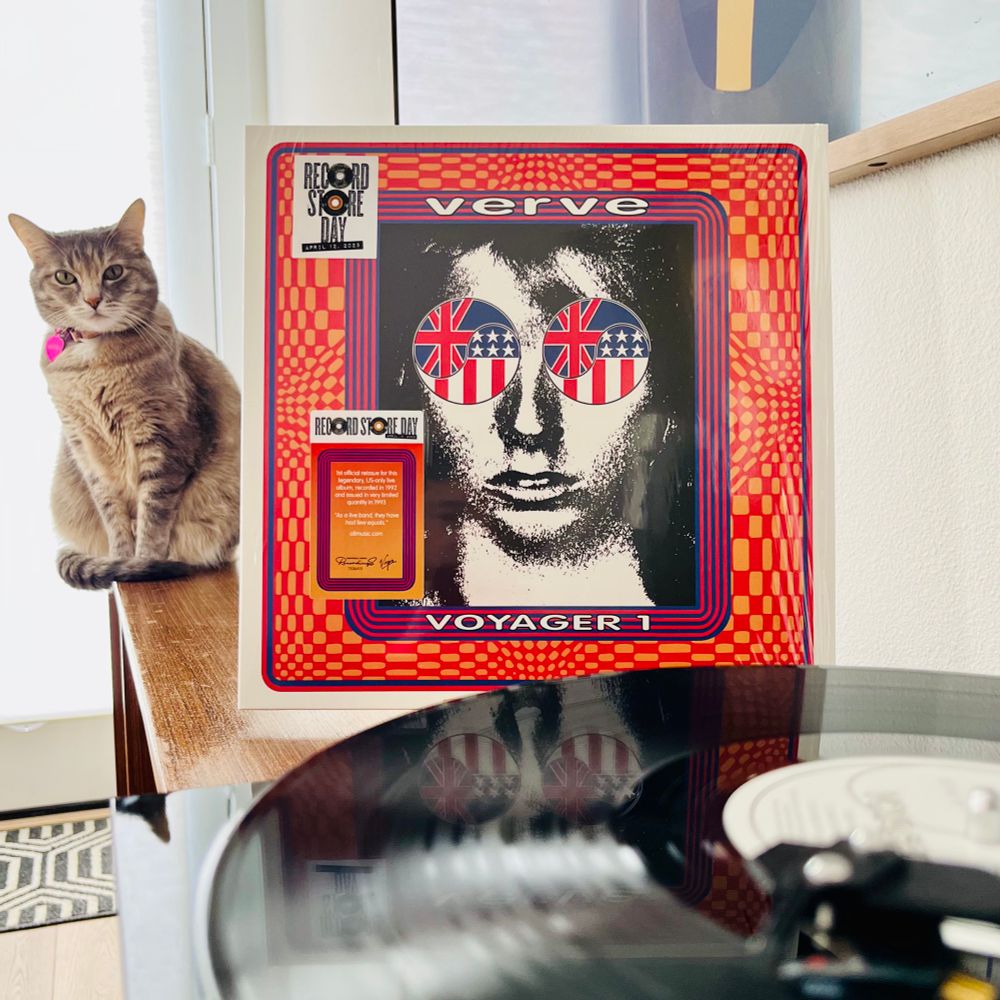 Torbie cat sitting next to jacket of Verve - Voyager. Record Store Day 2025 sticker on the shrinkwrap. Record spinning in the foreground #shoegaze #psychrock 