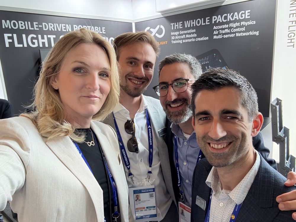 Laura, Cameron, and Jason from Infinite Flight posing with Jon Ostrower at the Infinite Flight booth at the Paris Air Show. 