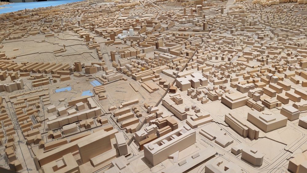 Almost unending wooden scale model of a city, with thousands of buildings down in the frame. The model blurred off the edge of all sides of the photo. 