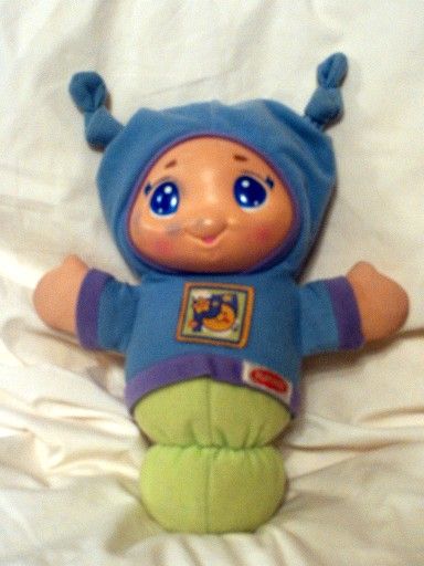 Lullaby Gloworm (2005). Soft doll of a Caucasian boy with blue eyes wearing a blue hoodie over a green sleeping bag.