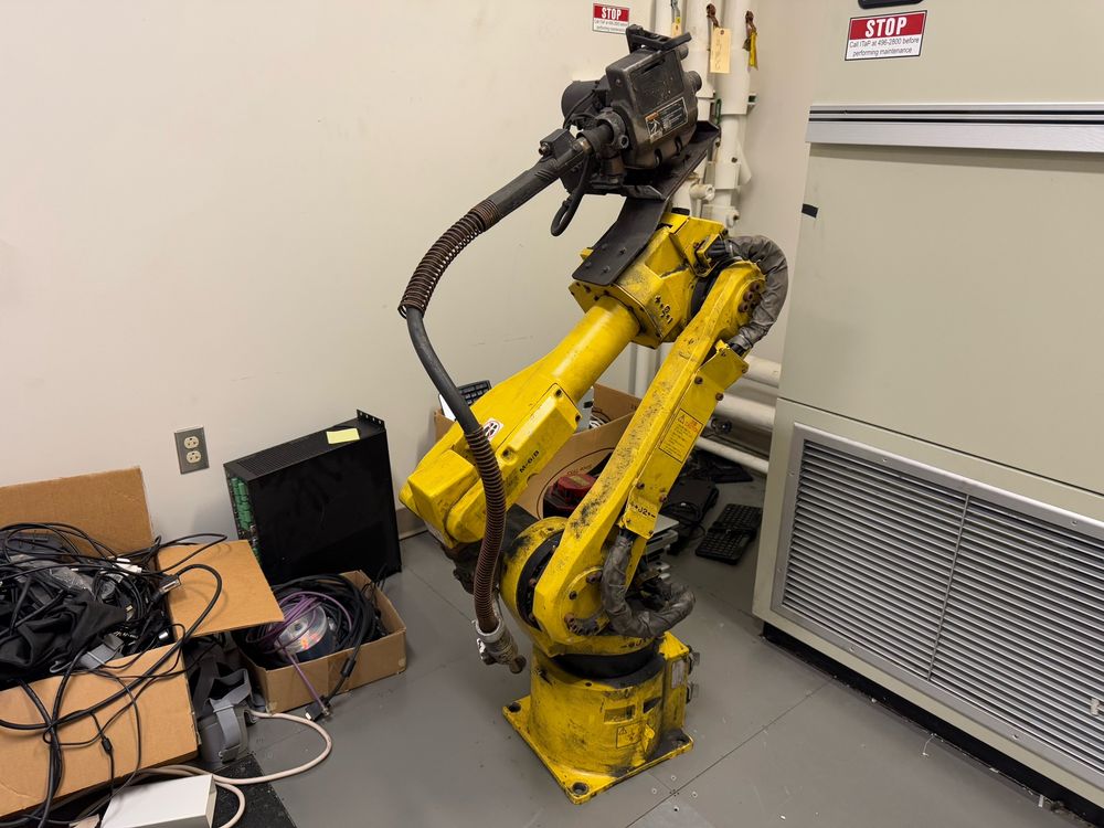 The yellow robot arm standing up in a room