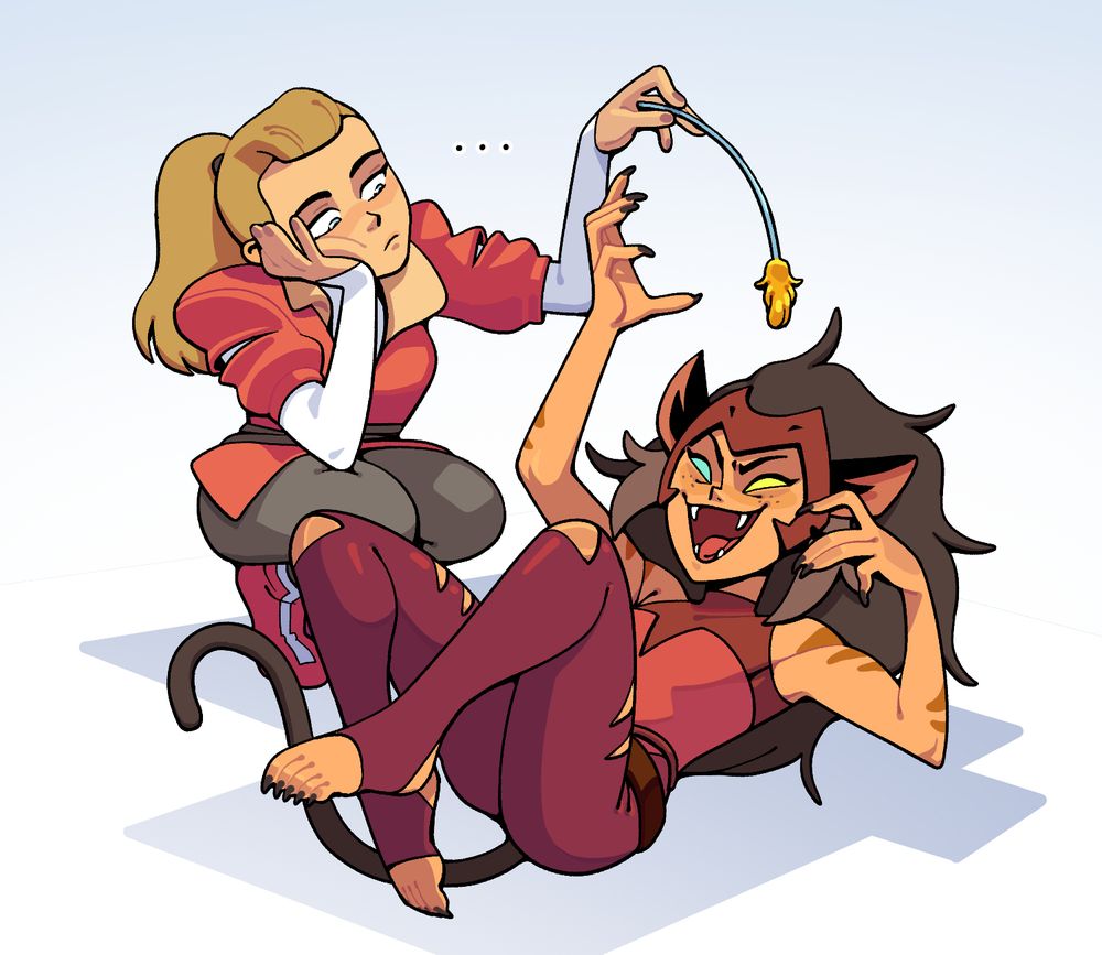 Catra writhing on her back as she swats up at She-Ra's sword, which has been shape-shifted to resemble a cattail pod and stalk and is being waggled by a very bored looking Adora who crouches beside her.