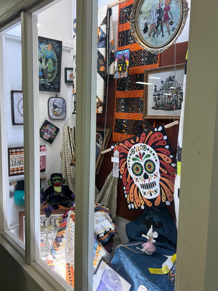 Hill’s excellent cross stitch in a display case with other Halloween-themed items at the State Fair Creative Activities Building