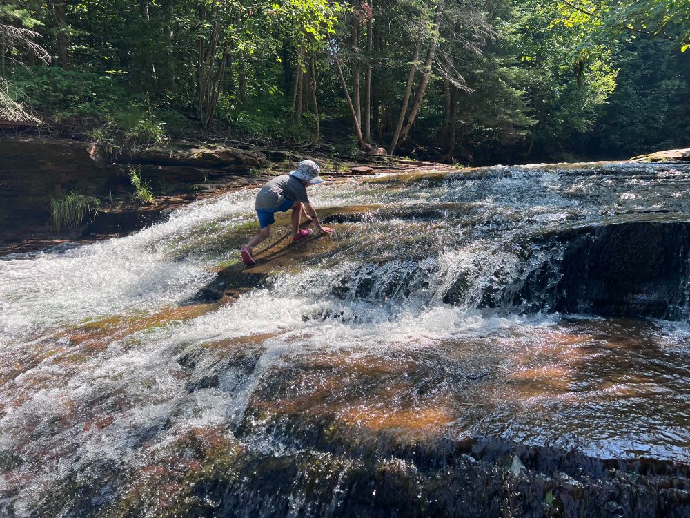 5 year old climbing Siskiwit Falls in the Siskiwit River