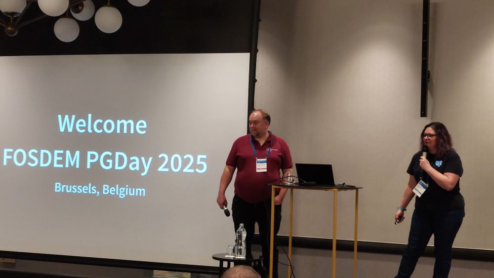 Karen Jex and Magnus Hagander introducing FOSDEM PGDay 2025 on stage 