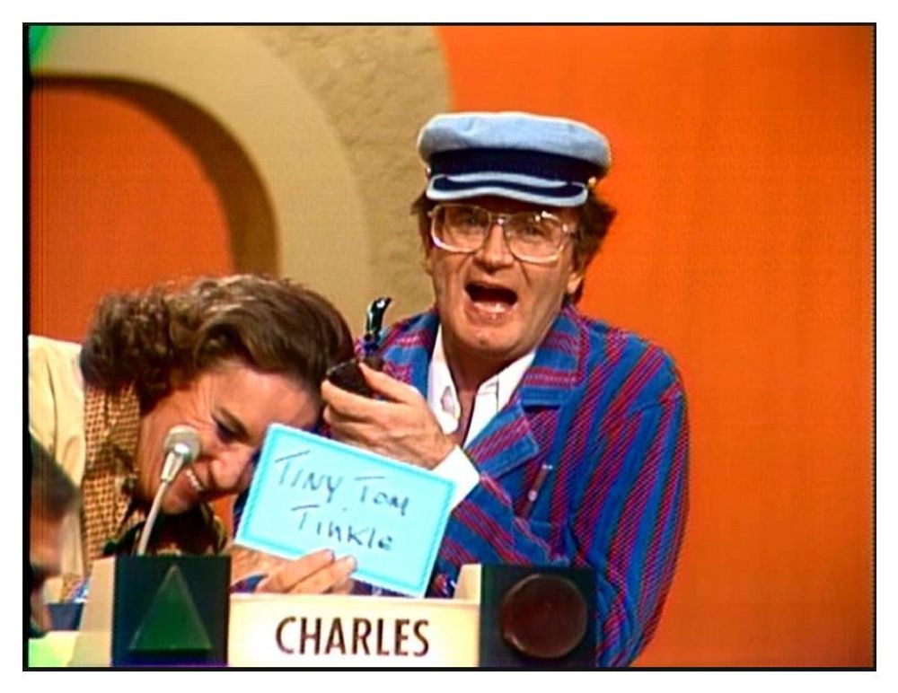 Bret Somers and Charles Nelson Reilly on the 70s version of The Match Game. Charles is holding a card that says “Tiny Tom Tinkle” against a very orange backdrop.