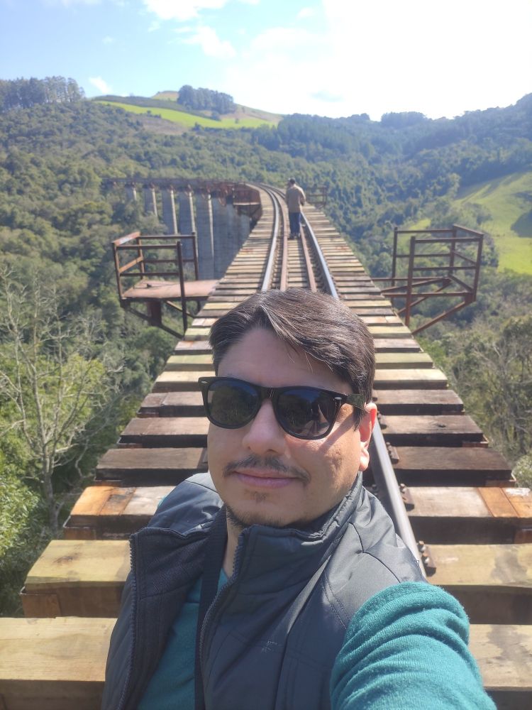 Homen de óculos escuros tirando selfie em um trilho