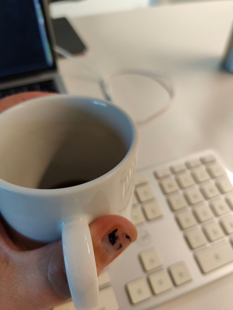 Fast leere Tasse, Tastatur und MacBook