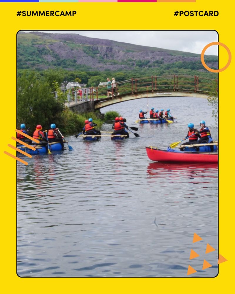 A group of young persons in helmets and life jackets paddling blue rafts under a small arched bridge on a calm river, surrounded by lush greenery and hills in the background. The photo has a yellow border with Mosaic’s orange graphic shapes, and includes the hashtags #SummerCamp and #Postcard.

