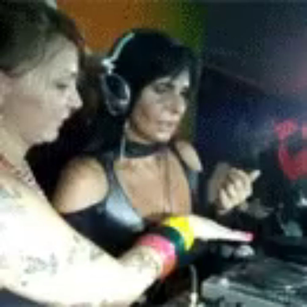 two women wearing headphones are sitting in front of a dj mixer .