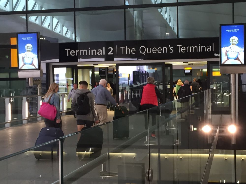 Entrance to a building at Heathrow, with a sign above the door reading "The Queen's Terminal"