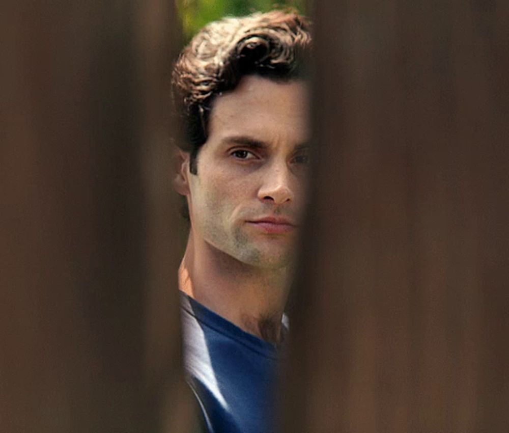 a close up of a man 's face behind a wooden wall