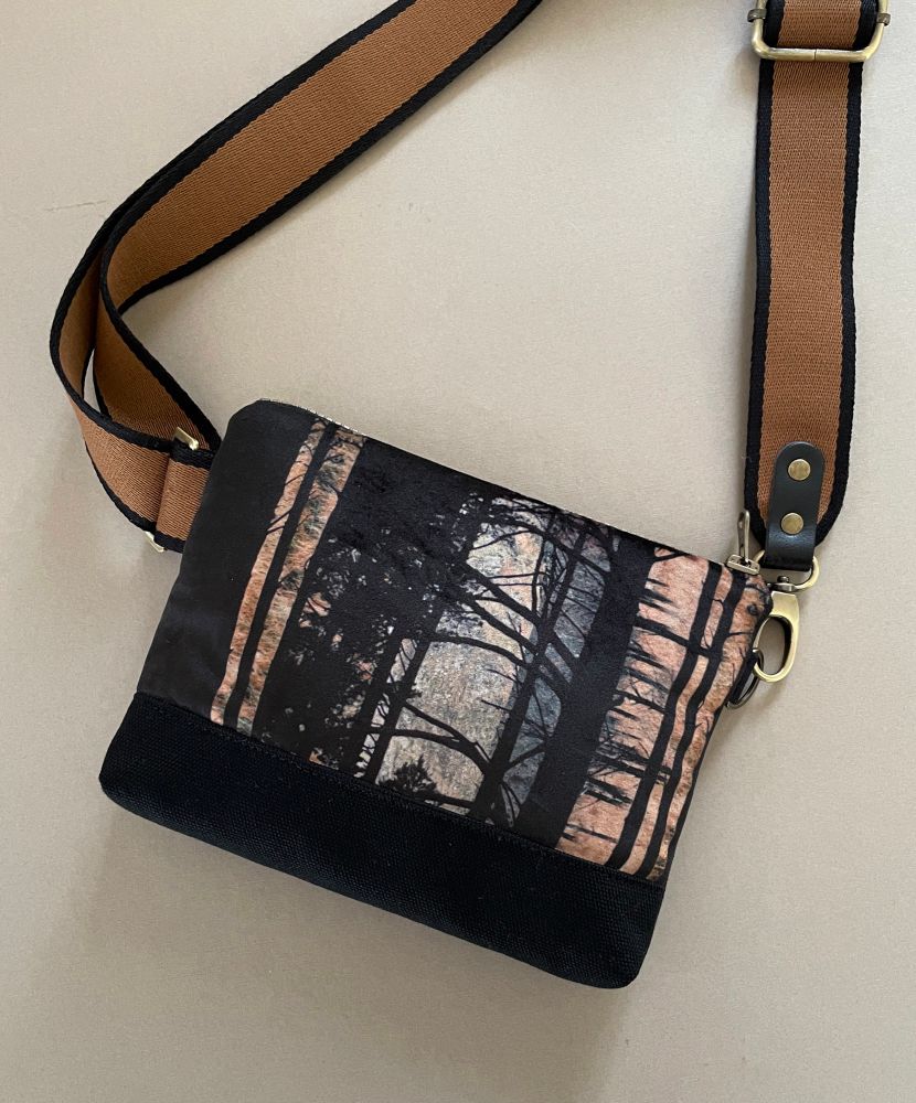 A handmade shoulder bag featuring a velvet printed panel of pine trees in a brown and black colour way 