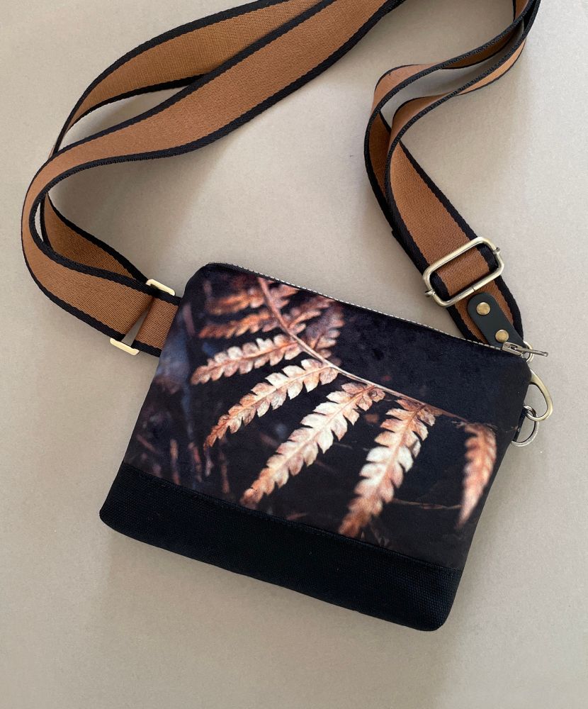 A handmade shoulder bag featuring a velvet printed panel of a fern frond in a gold, brown and black colourway 