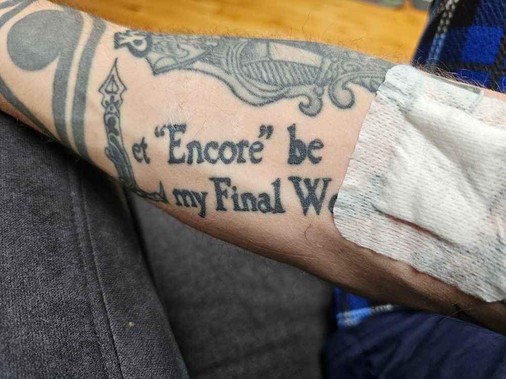 Tattooed arm with plaster after giving blood