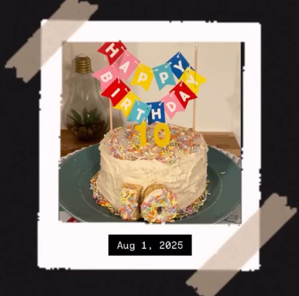 Birthday cake on a teal plate with rainbow sprinkles, a Happy Birthday banner, #10 candles, and a #10 on the front of the cake.