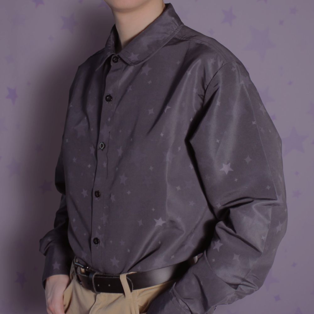 A long sleeve back button up shirt tucked into pants, with a subtle star pattern covering it.