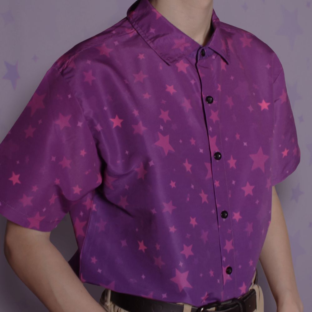 A short sleeve purple button up shirt tucked into pants, with a subtle star pattern covering it.