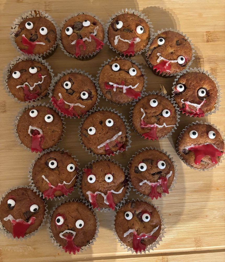 Braune Muffins mit Zuckergussgesicht und rotem Zuckerguss als Blut