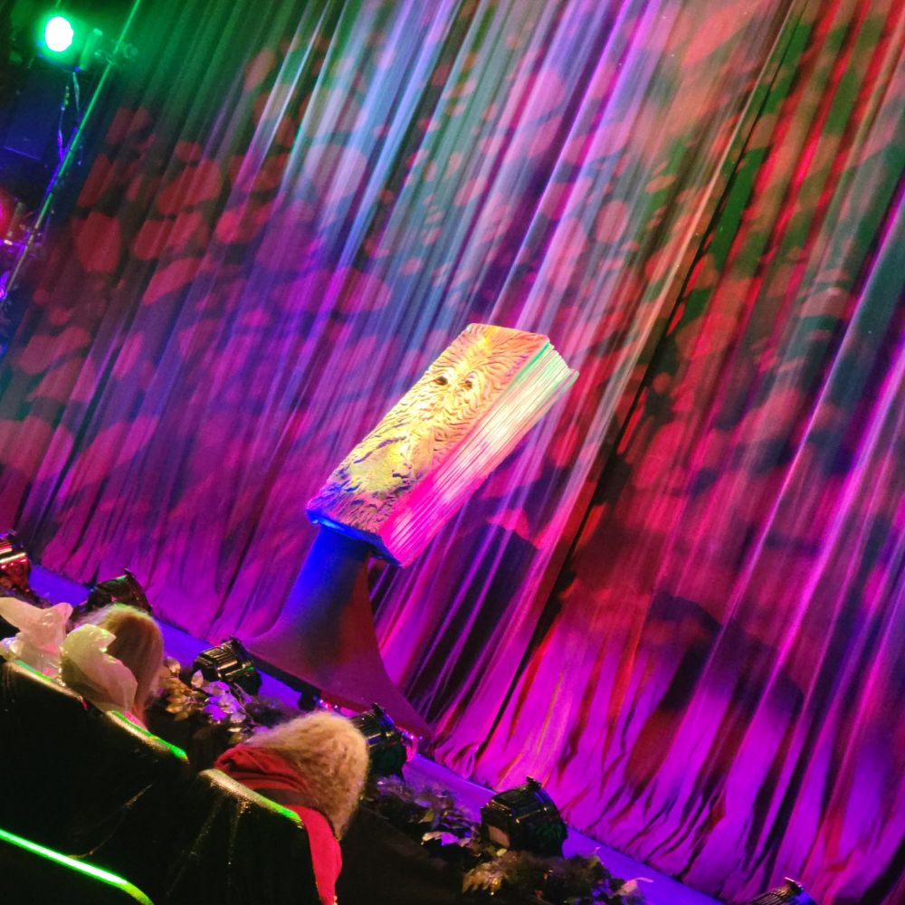Picture of a large necronomicon (book of the dead) on a brightly colored stage 