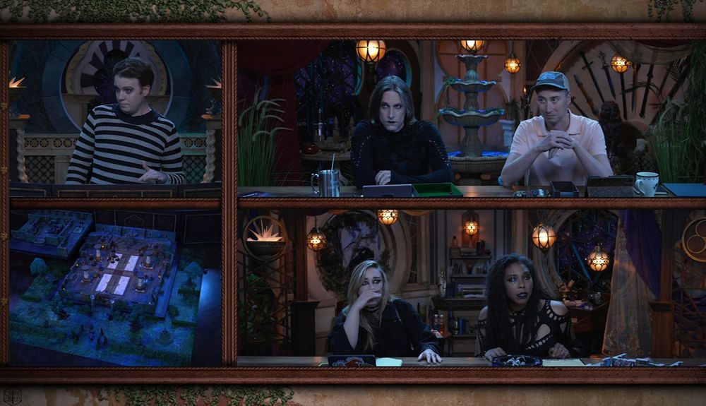 A screenshot from tonight's Halloween episode of Campaign 4.  Top Row, Left To Right: Brennan Lee Mulligan (Dungeon Master), Matthew Mercer (Sir Julien Davinos), and Alex Ward (Occtis Tachonis).  Bottom Row, Left To Right: Ashley Johnson (Vaelus) and Aabria Iyengar (Thaish Lloy).  Brennan is wearing a long-sleeved pullover shirt with an inch-wide black trim around the collar and Black and Gray stripes honoring Beetlegeuse.  Matthew and Ashley are in standard full cover Goth black, while Aabria has a really cute black top that looks like it's straps with a purposeful design of circular holes along one edge of the fabric strips criss-crossed around her neck and arms.  Alex, normally in Goth clothing, is wearing a salmon colored (I think, there is a lot of colored light influence) polo shirt with what appears to be a denim baseball cap.  It looks truly odd for Alex. LOL!  Matthew looks concerned, Ashley and Aabria look crestfallen, and Alex looks on slightly expressionless (although truth be told, he may be harboring a smirk).