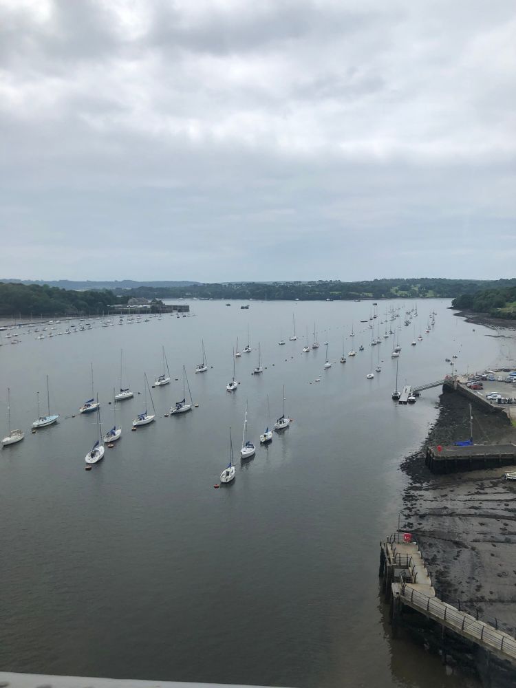 Estuary view from high vantage point with lots of boats moored up. 