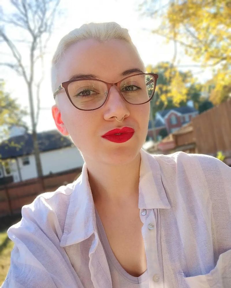 another photo of me, this time with my hair up so it looks slicked back! the background here is skies and trees, and I'm backlit wonderfully by the sun