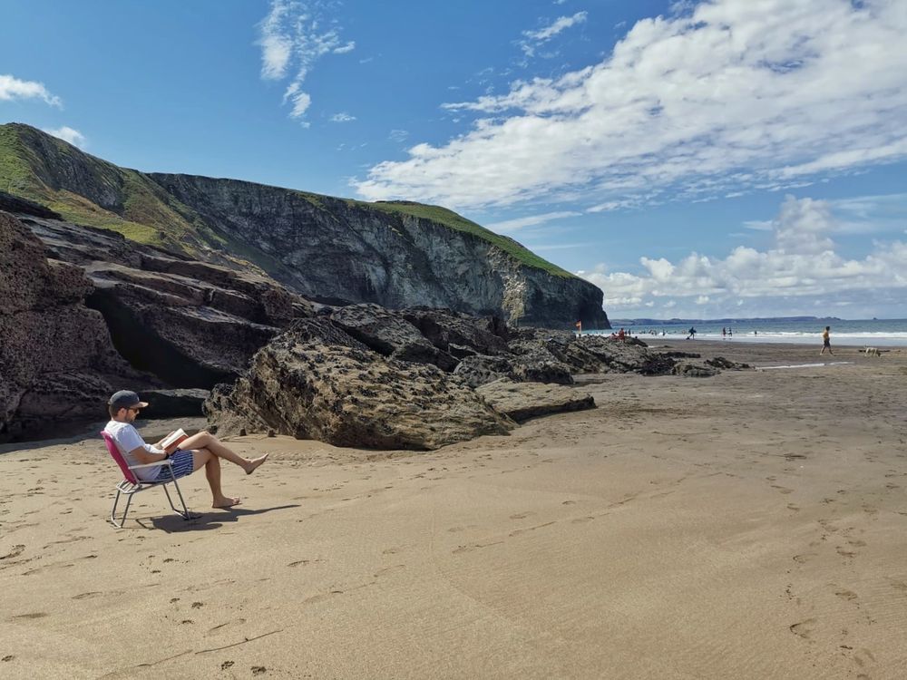 Ich im Klappstuhl am Strand beim Lesen 