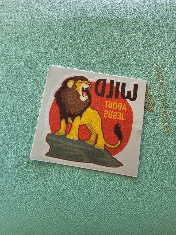 A temporary tattoo of a lion with the text reversed saying WILD About Jesus
