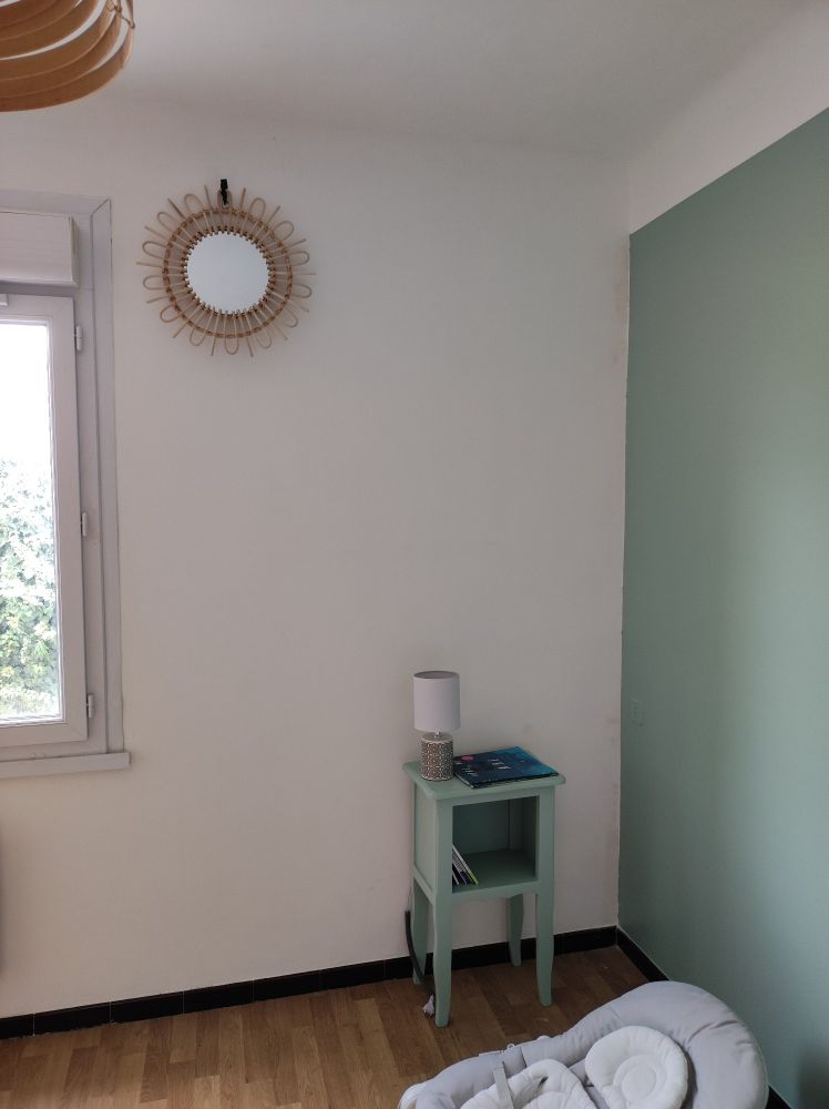 Mur peint en vert et petite table en bois assortie