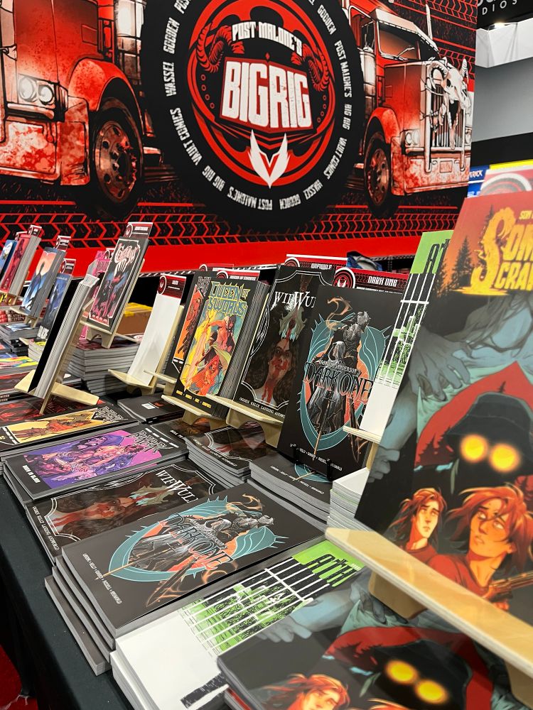Angled shot of the various and super-cool comics that Vault Comics has available, including THE DARK ONE by JAB client Brandon Sanderson